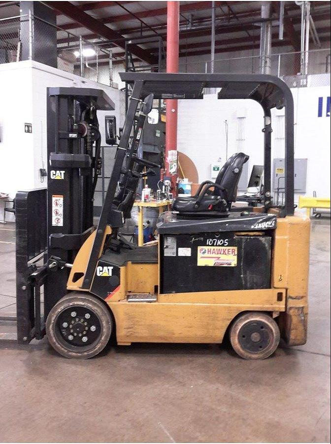 Opposite side view of refurbished 2012 Cat E6000 4‑wheel electric forklift showing operator compartment, 48 volt chassis, solid tires, load backrest, 3‑stage mast with side shift, and CSA certification decal during Brampton deployment.
