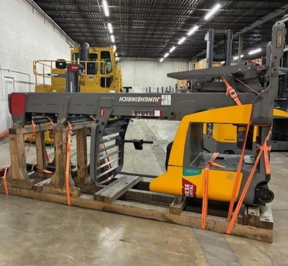 Opposite side view of a 2019 Jungheinrich ETR335D reach truck laid down and cradled with battery removed, showing mast rails, chassis frame, and drive unit.