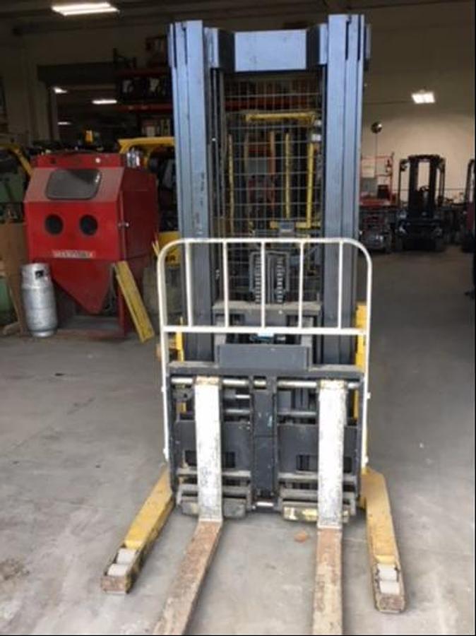 Front view of refurbished 1997 Yale MRW030 electric walkie straddle stacker reach showing triple stage mast fully lowered, 48" forks, CSA certification decal, and operator handle during Ontario deployment.