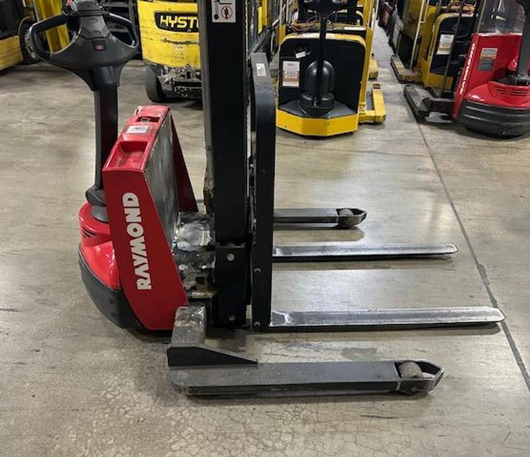 Side view of 2012 Raymond RAS25 electric walkie straddle stacker – CSA-certified 2,500 lb chassis-only unit with triple mast, adjustable straddle legs, and ergonomic tiller controls shown fully reconditioned and staged in Brampton ON – Premier Lift Equipment