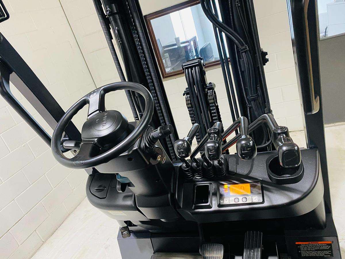 Operator dashboard of Toyota 8FBCU20 COM electric sit-down forklift showing steering wheel, multi-function display, and CSA-certified controls – unit staged in Brampton ON