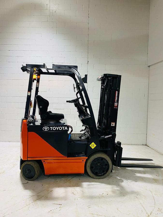 Opposite side view of Toyota 8FBCU20 COM electric sit-down forklift showing battery compartment, cab entry, and CSA-certified chassis – unit staged in Brampton ON
