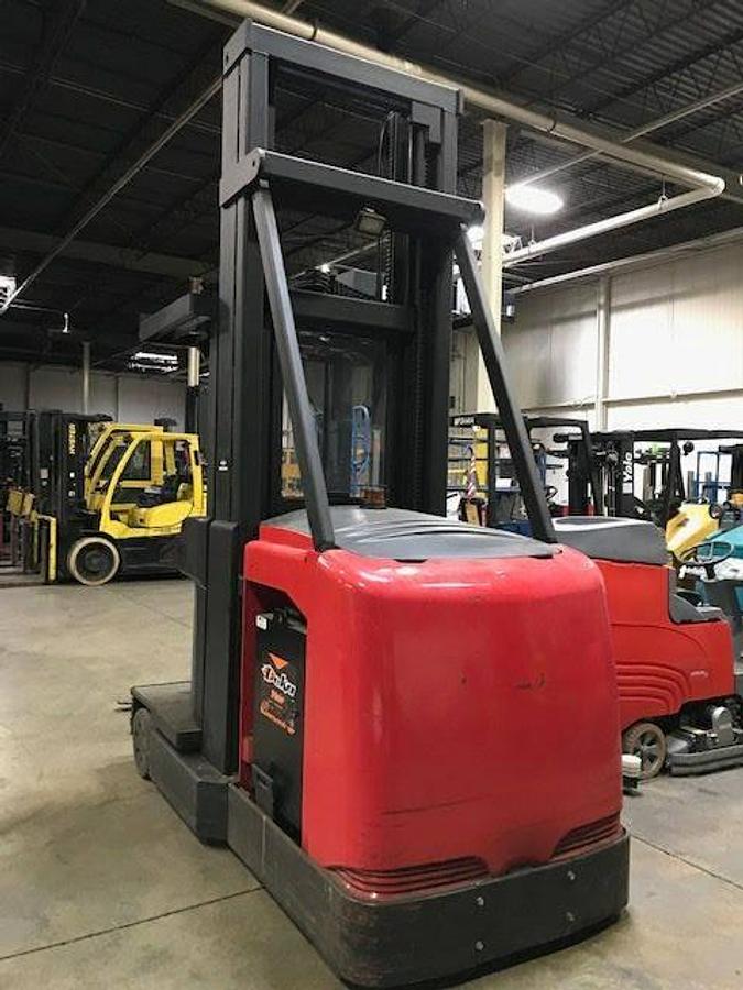 Opposite rear angle side view of refurbished 2001 Raymond SA-CSR30TWG electric man-up turret truck showing safety rails, wire guidance sensors, and rear frame during Ontario deployment