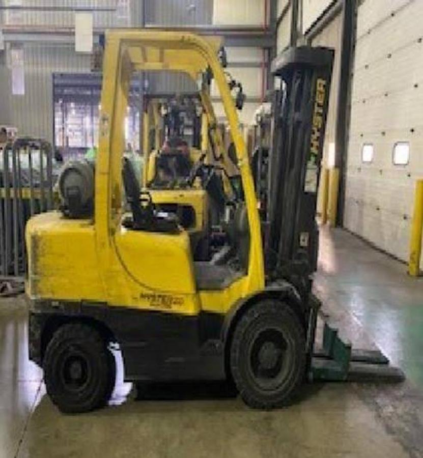 Opposite side view of refurbished 2018 Hyster H70FT LP Gas forklift showing counterweight, cab enclosure, and CSA certification decal during Ontario deployment.