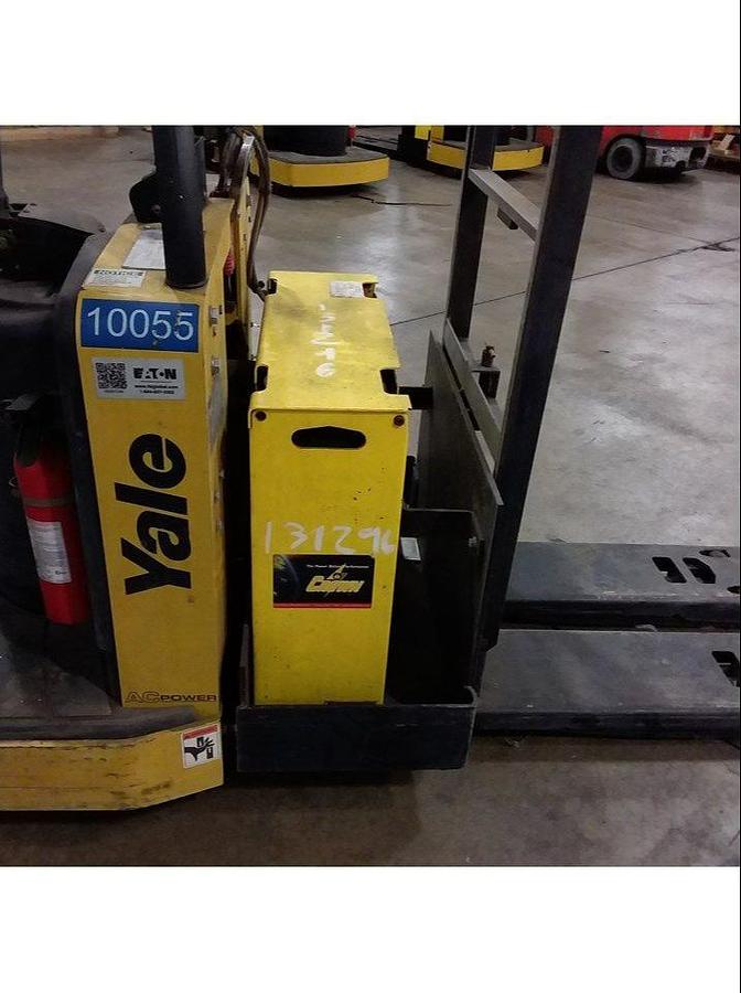 Close-up view of refurbished Yale electric pallet jack battery pack showing modified bracket, built-in charger connections, and CSA inspection decal during Ontario deployment