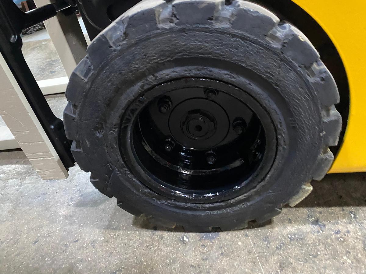 Left solid pneumatic drive tire showing wheel hub and CSA spec