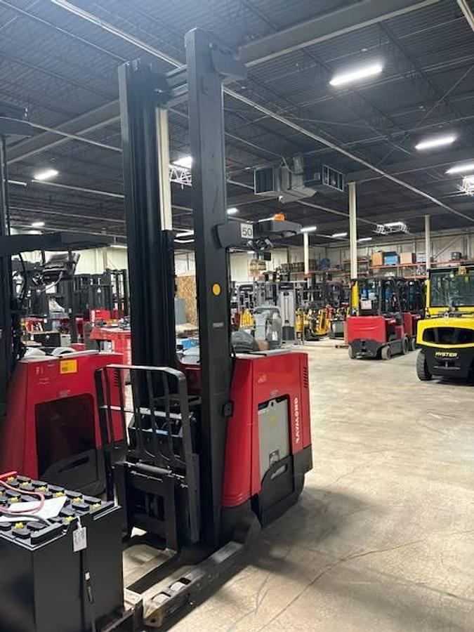 Front side angle of Raymond 750DR32TT deep-reach forklift showing 268" triple mast, reach carriage, directional wheels, and narrow aisle chassis during Brampton deployment