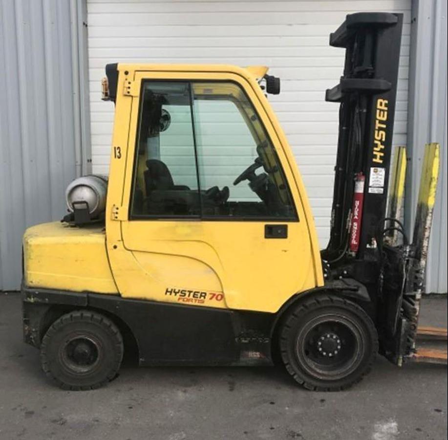 Opposite side view of refurbished 2012 Hyster H70FT LP Gas forklift showing counterweight, cab enclosure, and CSA certification decal during Ontario deployment.