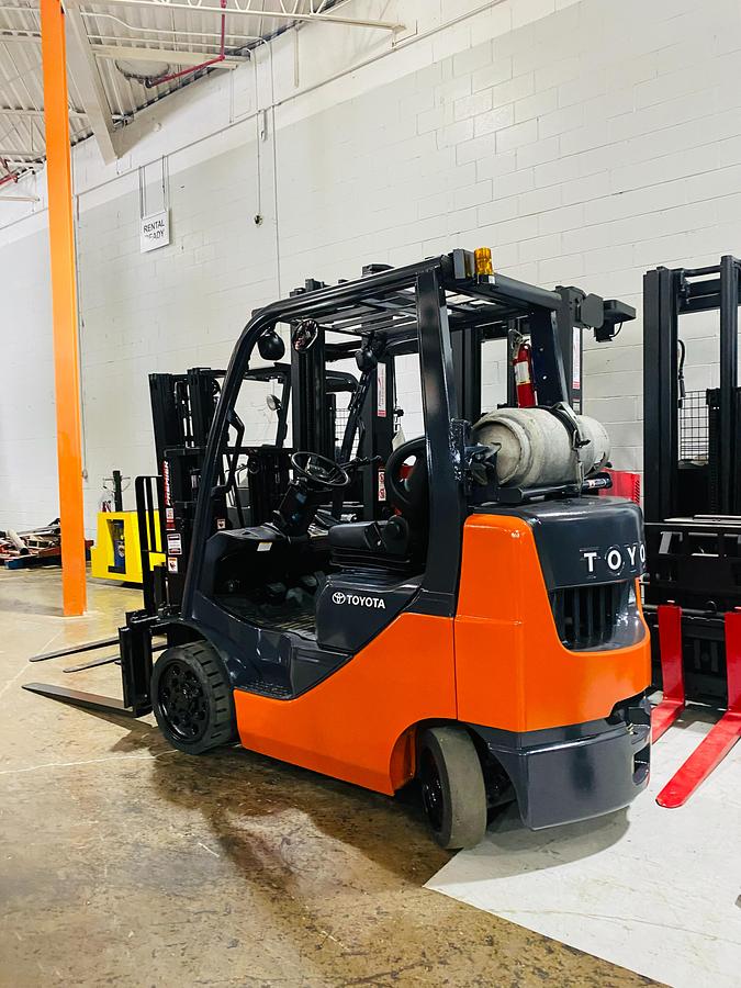 Rear side angle of 2011 Toyota 8FGCU20 propane forklift – CSA-certified 4,000 lb chassis showing counterweight, traction cushion tires, and propane tank bracket with safety decals applied, Brampton ON – Premier Lift Equipment