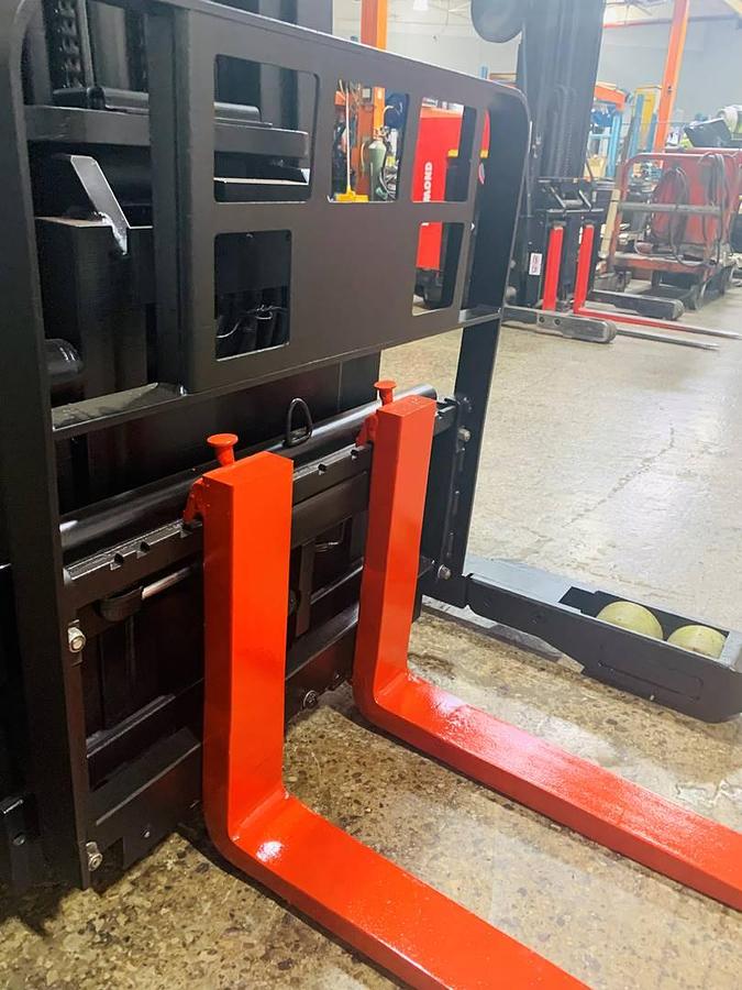 Close-up view of refurbished 2000 Raymond EASIR40TT electric reach truck showing side shift carriage, fork tips, and mast rails during Mississauga deployment