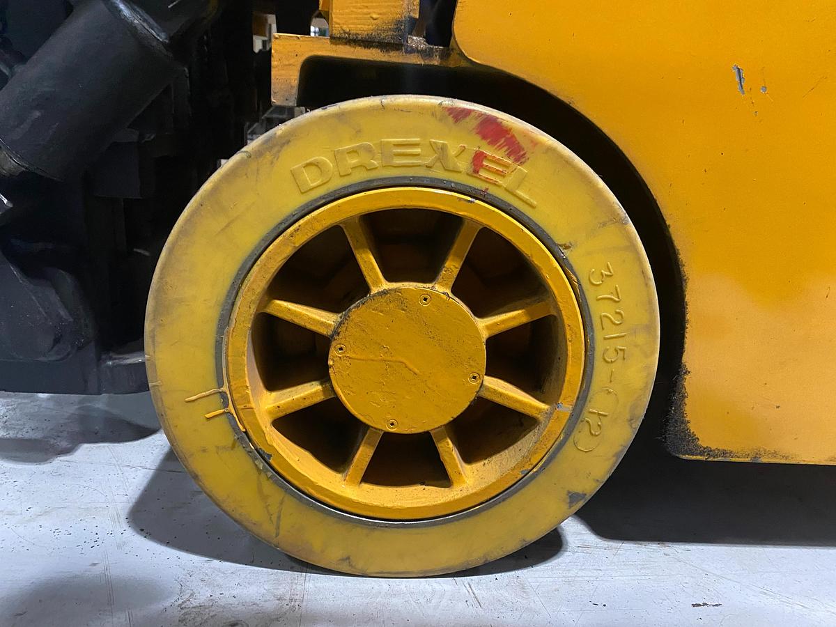 Left non-marking poly drive tire on Drexel SLT30 electric swing mast forklift showing wheel hub and CSA indoor spec – unit staged in Brampton ON