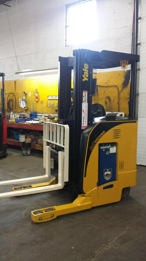 Side view of refurbished 2006 Yale NR040 electric reach truck showing mast rails, CSA decal, and 42" forks during Ontario deployment
