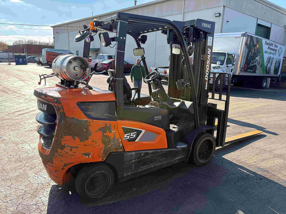 Opposite side view of 2021 Doosan GC55C‑9 12,000 lb cushion tire LPG forklift showing counterweight, LPG tank area, and cushion tires