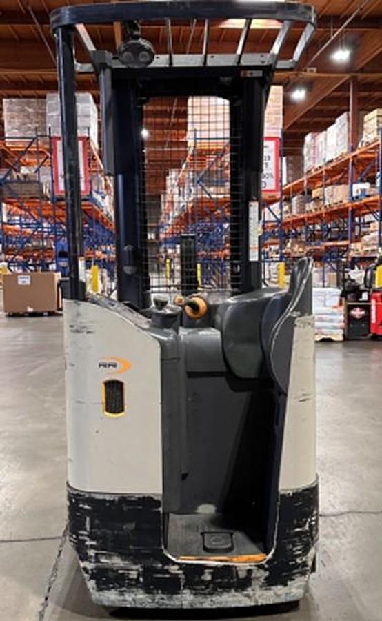 Back view of Crown RR5725-35 electric reach forklift showing CSA-certified operator compartment with forward-facing controls, cushioned side-stance platform, overhead guard, and fingertip steering – staged in Brampton ON – Premier Lift Equipment