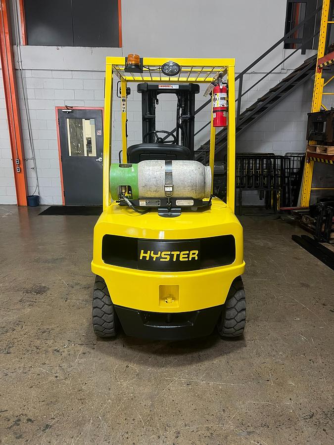 Back view of Hyster H50XM propane pneumatic forklift – CSA-certified 5,000 lb chassis with rear counterweight, overhead guard, and propane tank bracket shown refurbished and sold chassis-only – safety-tagged in Brampton ON – Premier Lift Equipment