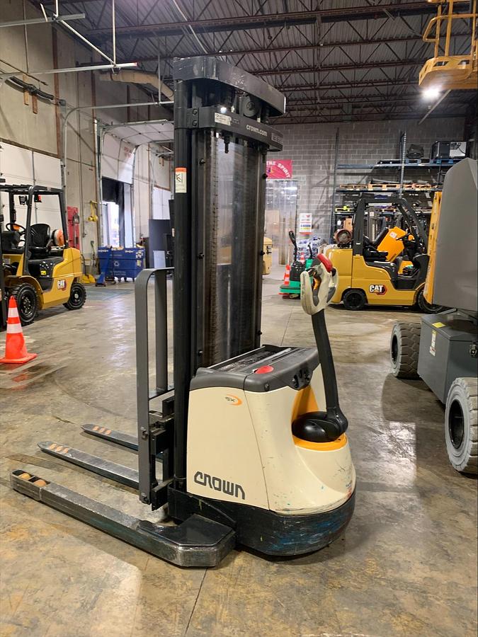 Opposite angle view of Crown SX3000-40 electric walkie straddle stacker showing mast carriage, forks, and CSA-certified chassis – unit staged in Brampton ON
