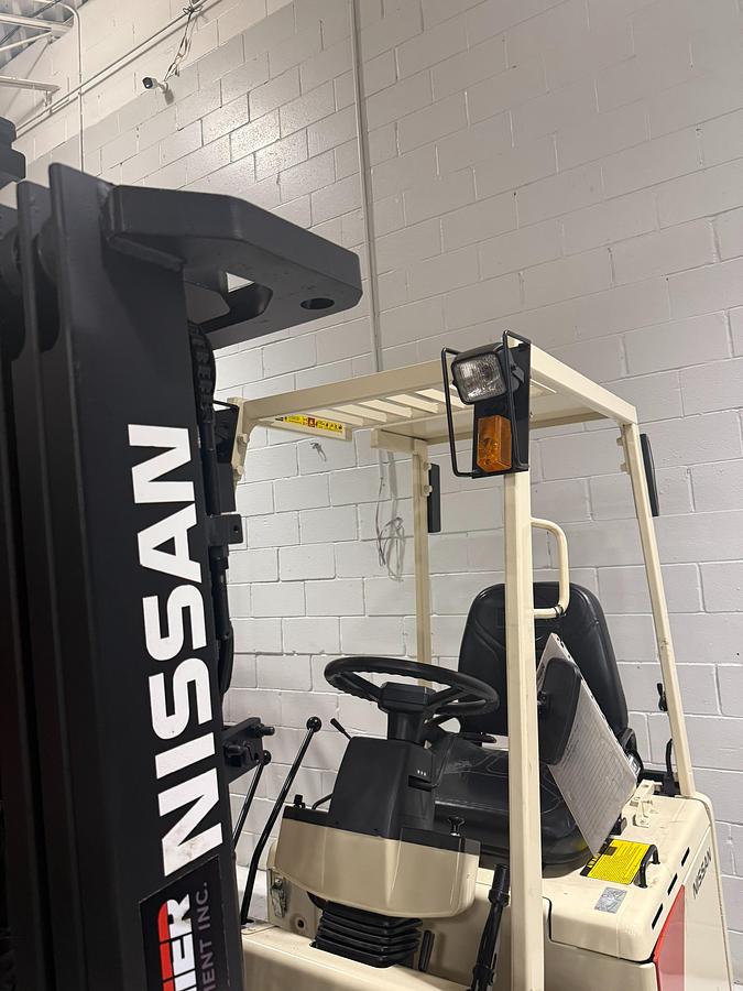 Angled mast view of Budget Nissan CUM01L15SN older electric forklift, non‑CSA, 187-inch triple mast.