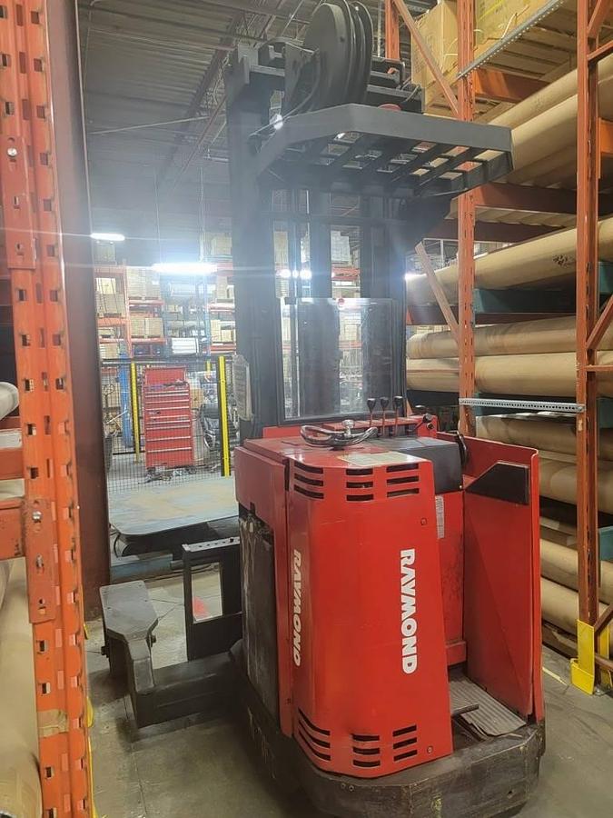 Rear view of Raymond 21-4DR40TT multi-directional forklift showing counterweight, operator cab, and original decals during pre-refurbish staging