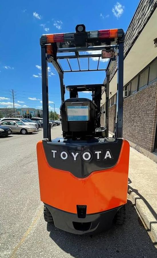 Rear view of Toyota 8FBCU25-EE electric forklift highlighting counterweight, safety decals, and CSA certification during warehouse deployment