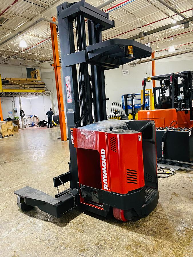 Side profile of 2001 Raymond EASI 4D-R45TT electric reach truck showing directional wheels, mast rails, and narrow aisle chassis during Brampton deployment