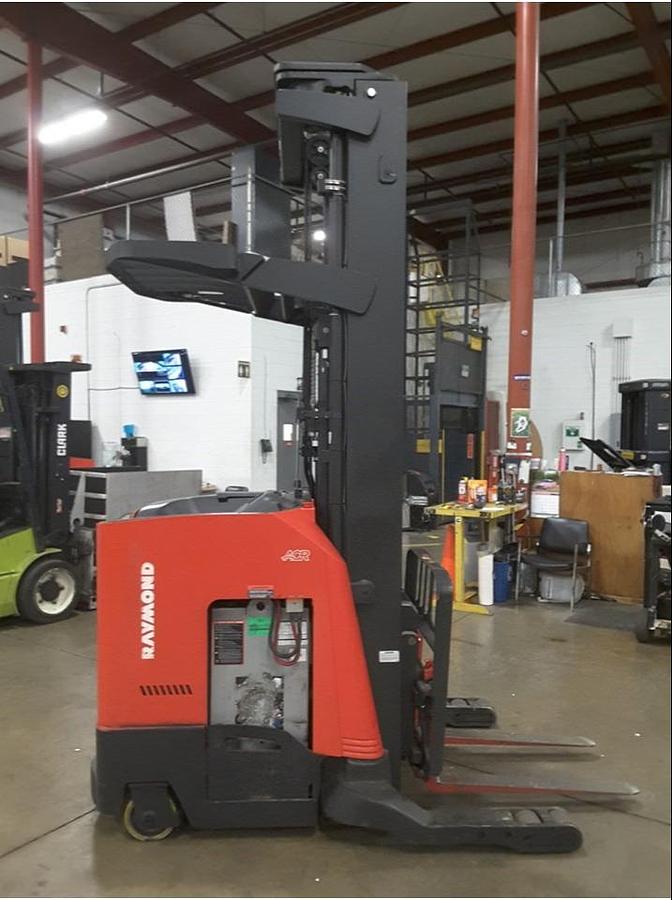 Side view of refurbished 2013 Raymond 750R45TT narrow aisle reach truck showing mast, forks, and CSA certification decal during Brampton deployment