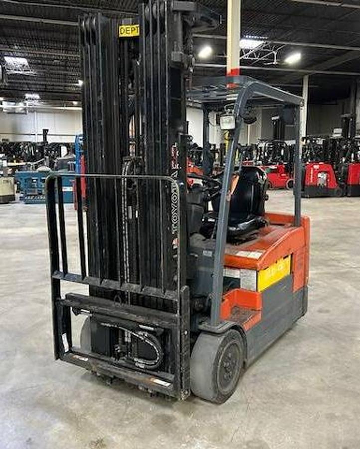 Front angle side view of refurbished 2012 Toyota 7FBEU20 electric 3-wheel sit-down forklift showing fork tips, mast extension, and CSA certification decal during Ontario deployment