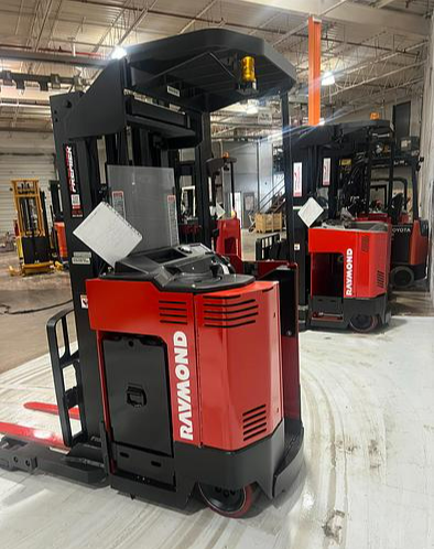 Side profile of Budget Raymond 31I‑R45TT stand‑up reach truck — narrow chassis and 180” mast.