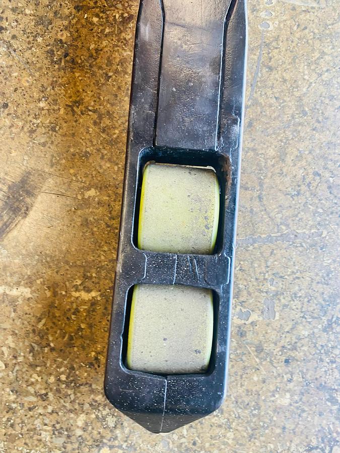 Close-up of Raymond 750-R45TT forklift straddle leg load wheels – poly cushion rollers mounted under baselegs for pallet support and smooth indoor travel