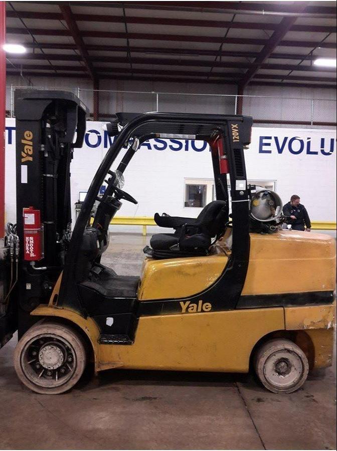 Opposite side profile of refurbished 2011 Yale GLC100VX LPG cushion forklift showing 4-way hydraulic carriage, 2-stage mast, and cushion tires during Brampton deployment