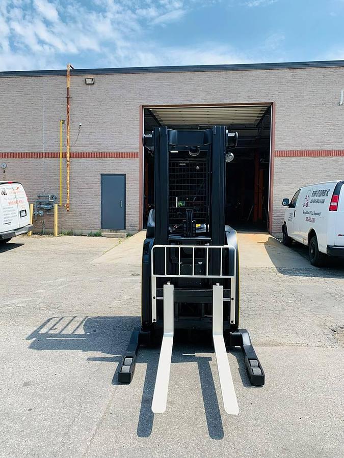 Front Angle Side View Front angle side view of refurbished 2018 Yale NR045EB electric reach truck showing fork tips, mast rails, and CSA certification decal during Ontario deployment
