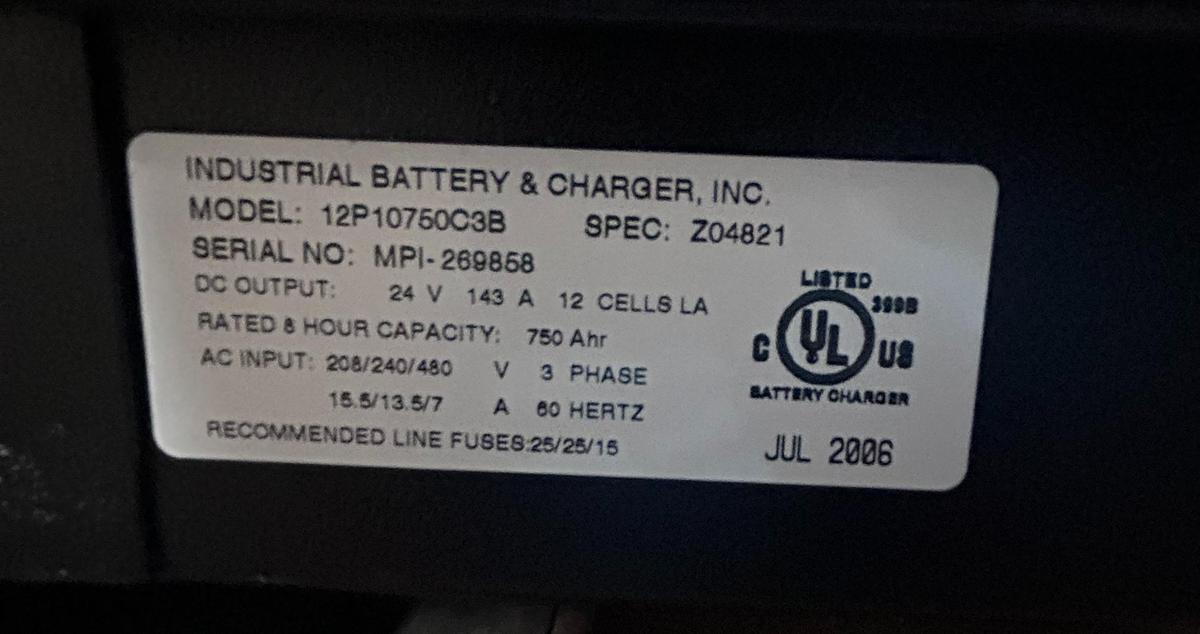 Manufacturer data plate showing model 12P10750C3B, serial MPI‑269858, 24V 124A output, 12‑cell 750 Ahr lead‑acid specifications, and 208/240/480V 3‑phase input ratings.