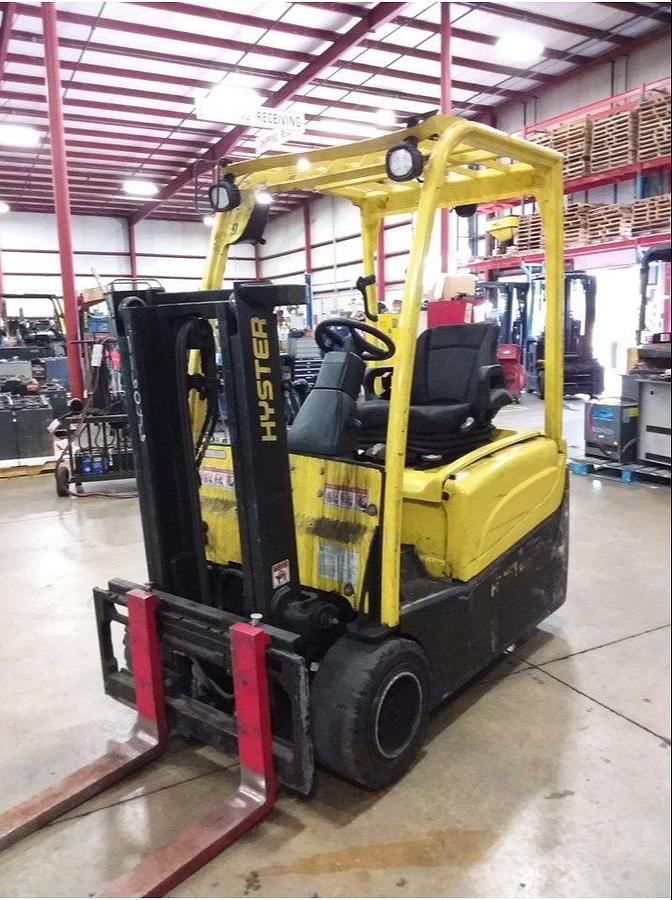Front side view of refurbished 2012 Hyster J40XNT 3‑wheel electric forklift showing truckers mast, 42" forks, side shift attachment, cushion tires, and CSA certification decal during Ontario deployment.