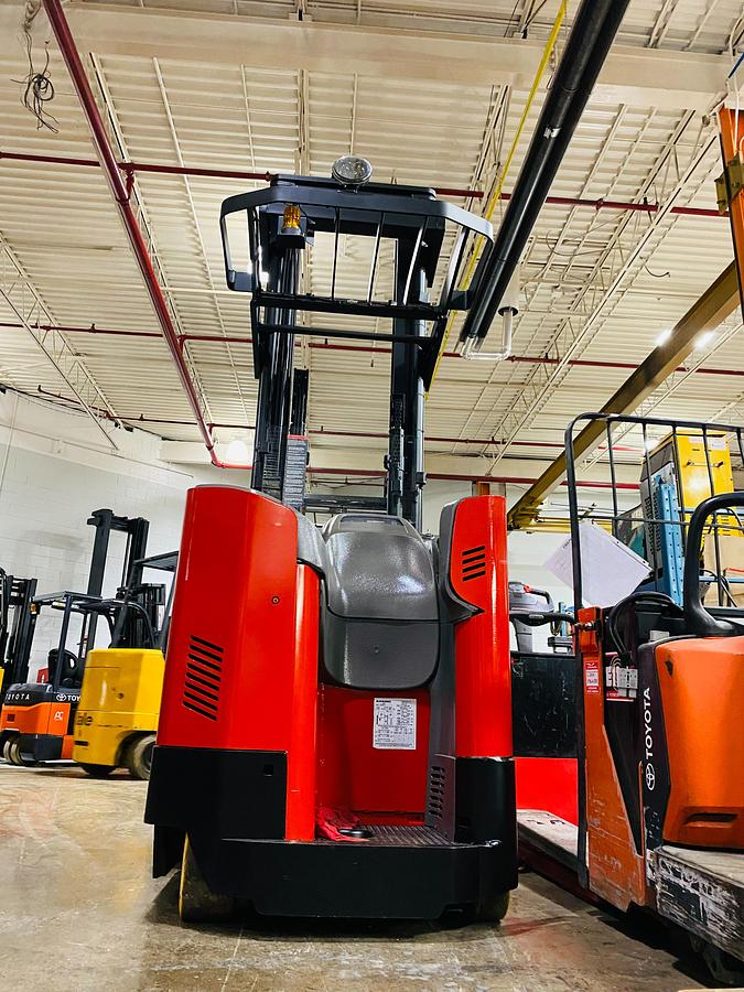 Rear-side view of refurbished Raymond 750DR32TT electric deep-reach forklift showing operator compartment, steering wheel, instrument cluster, rear chassis layout, and CSA safety decals during Brampton deployment