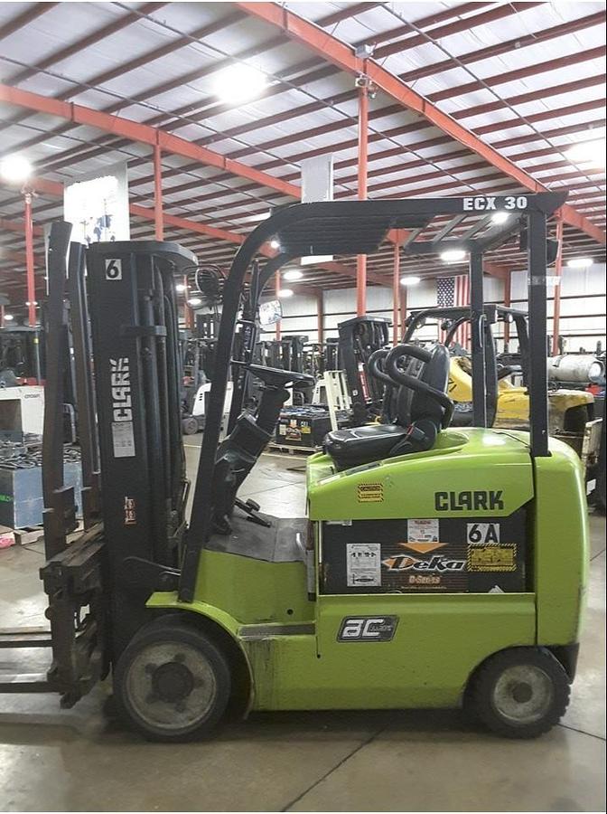 Opposite side view of refurbished 2014 Clark ECX30 4‑wheel electric forklift showing operator compartment, 48 volt chassis, 4‑way hydraulics, and CSA certification decal during Brampton deployment.