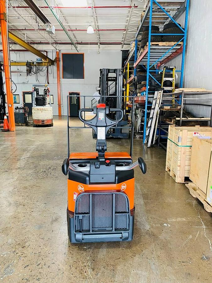 Behind view of refurbished 2016 BT LPE200/8 electric walkie/rider pallet jack showing rear chassis, flip‑down operator platform, load backrest, battery compartment, and CSA certification decal during Ontario deployment