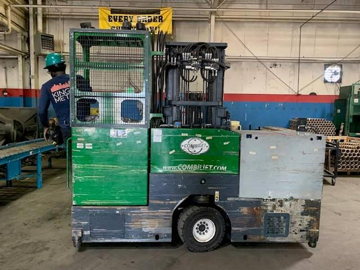 Back view of refurbished 2013 Combilift C6000EST electric multi‑directional forklift showing rear chassis, solid pneumatic tires for outdoor use, operator compartment, and CSA certification decal during Ontario deployment.