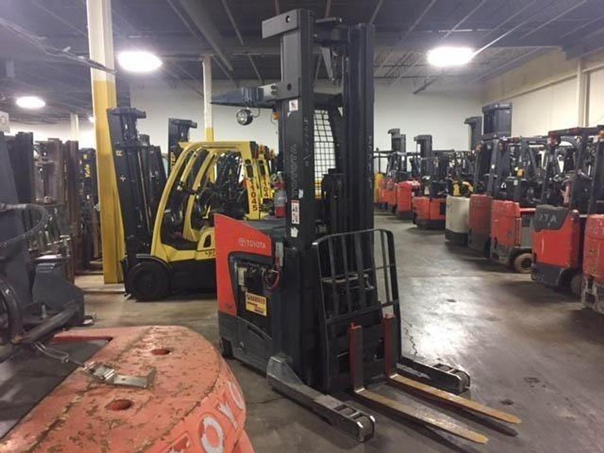 Angled front-side view of 2014 Toyota 8BRU23 electric single reach forklift with forks extended and mast retracte