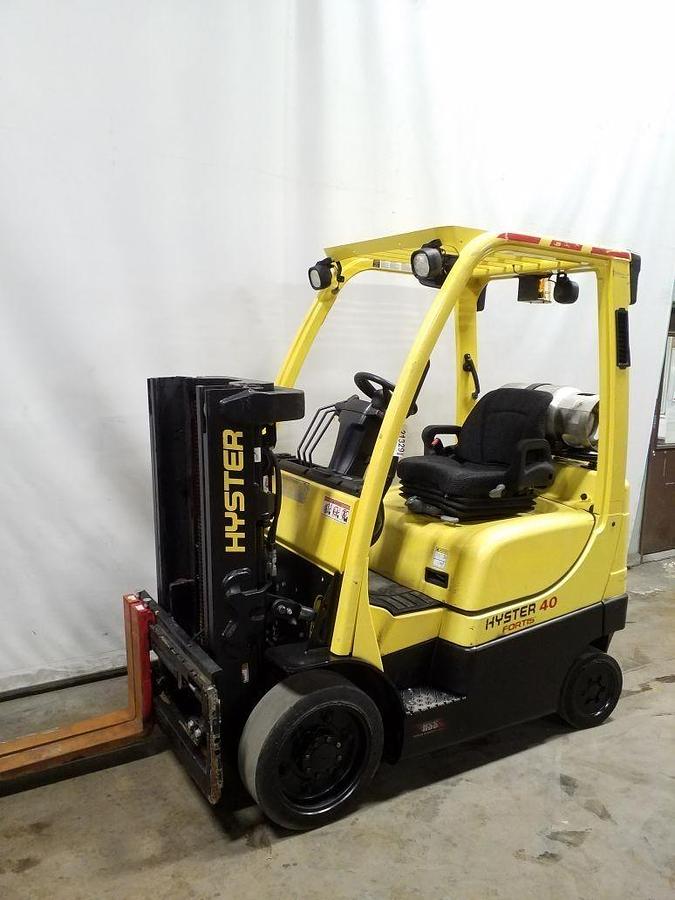 Front side view of refurbished 2014 Hyster S40FT LP Gas forklift showing 42" forks, truckers mast with side shift, headlights, solid black tires, and CSA certification decal during Ontario deployment.