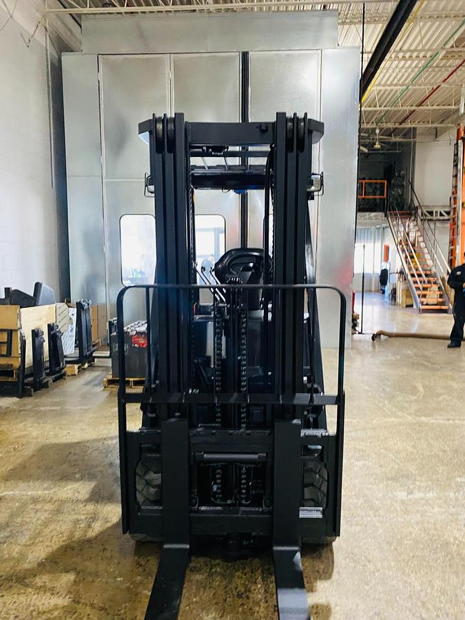 Head-on view of 2020 Toyota 8FBCU32-EE electric forklift with forks lowered, triple mast extended, and CSA safety markings visible