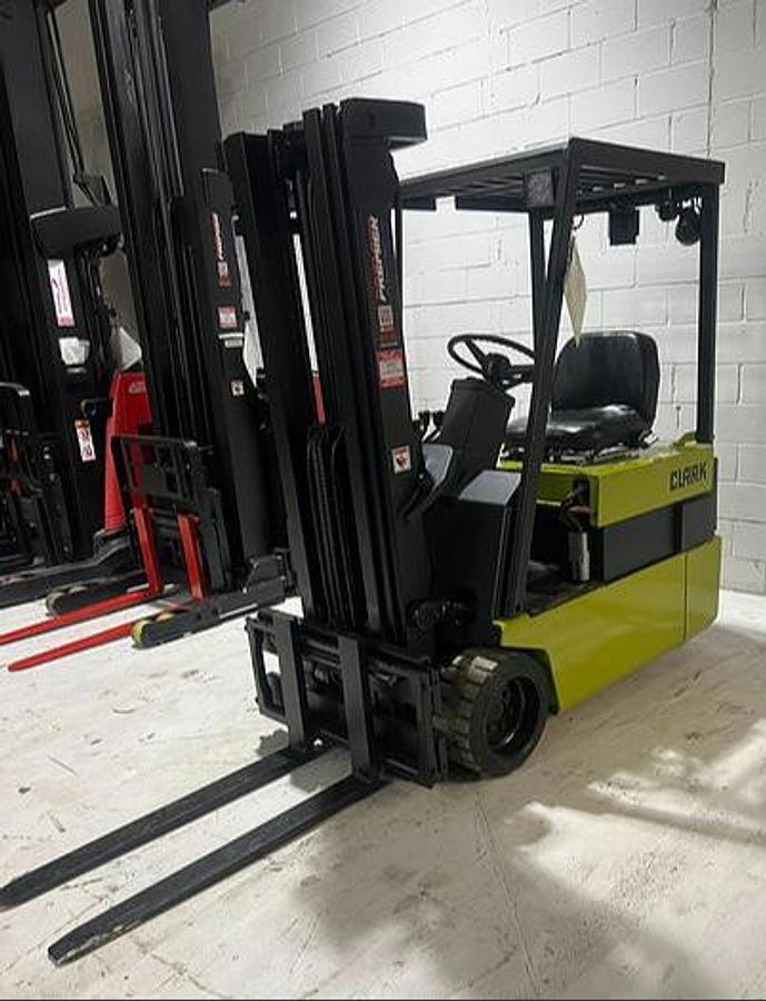 Front angle view of Budget Clark TM20 electric forklift, older non‑CSA unit with used battery and charger for light‑duty applications.