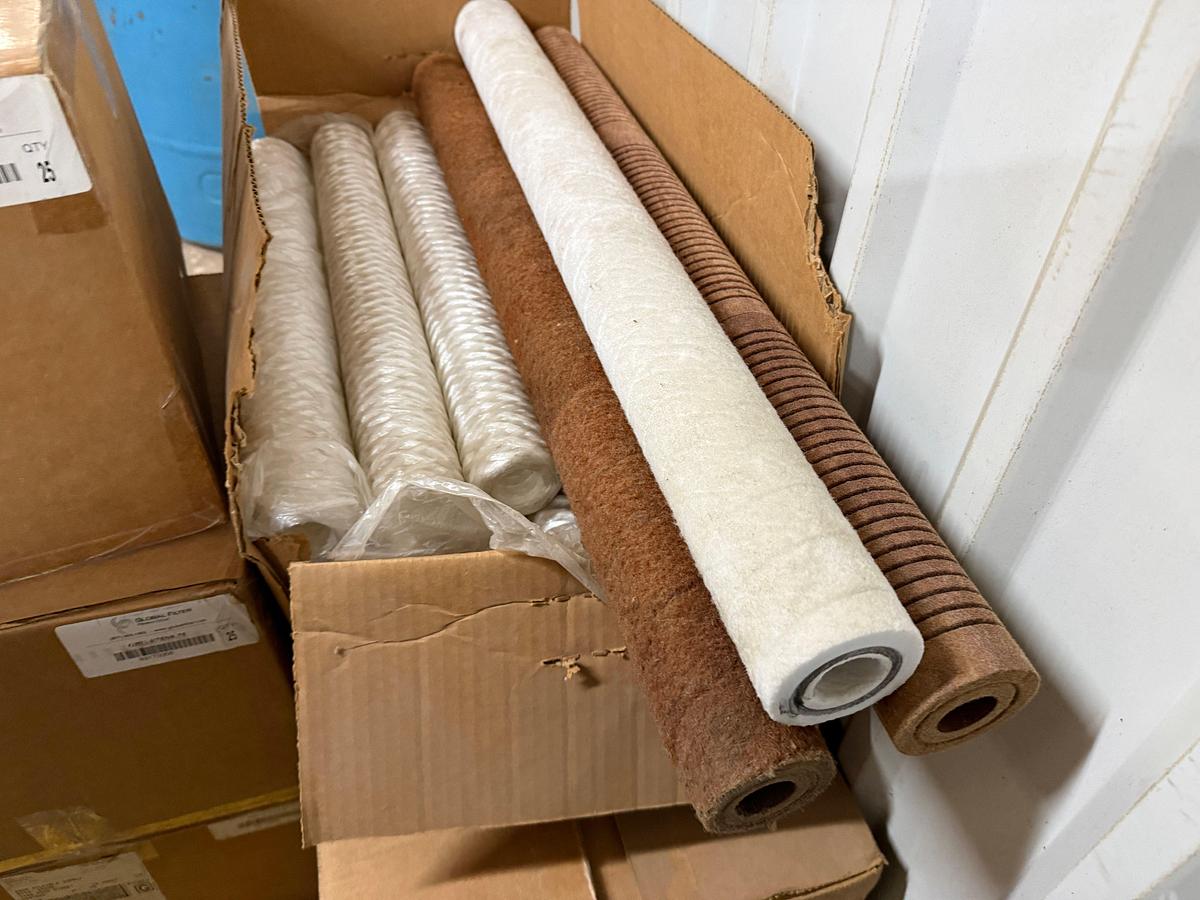 Used Section of  MOSTLY Global Filter industrial filter cartridges (part number GRU-V75N9.75, quantity 100+), Box of Camlock Fittings