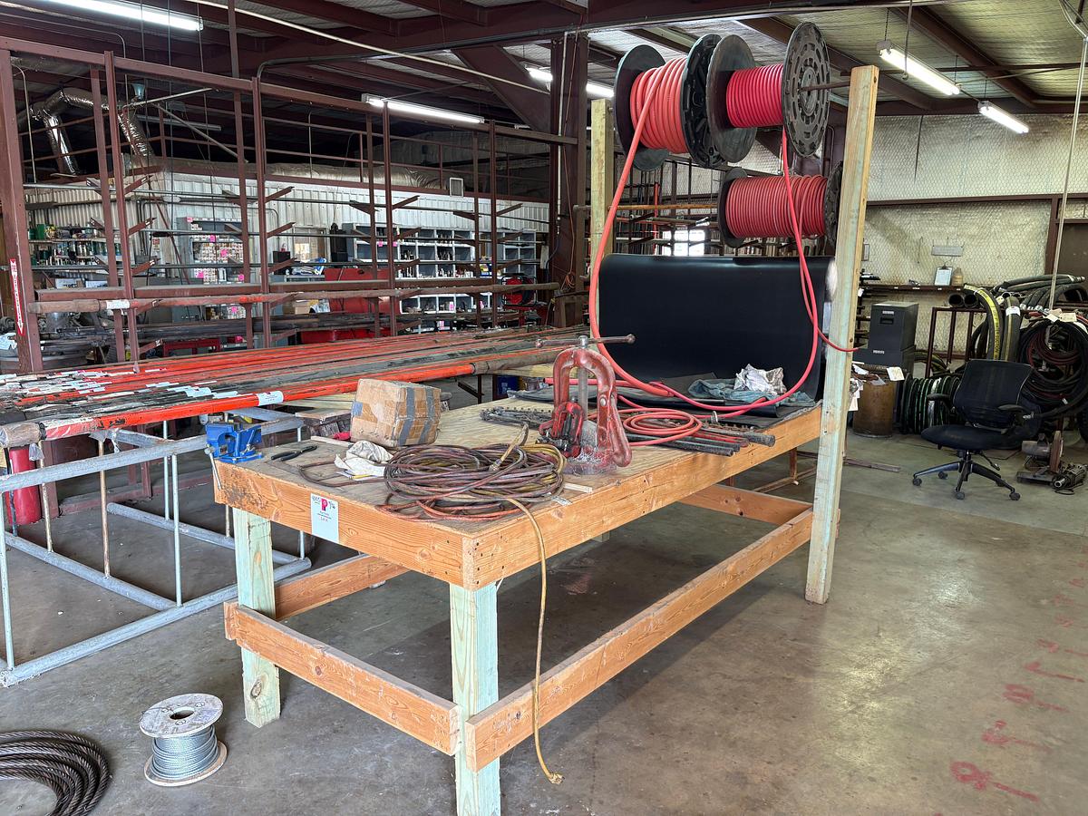Used 8’ x 4’ x 8’ wooden shop table W/ bench vise, pipe vise, built in spool rack, 9/16” to 1-1/8” rubber hose, extension cords, etc
