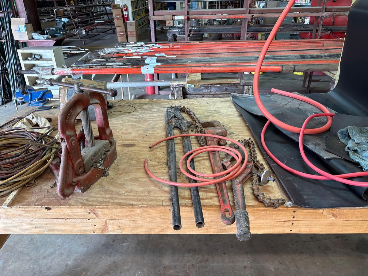 Used 8’ x 4’ x 8’ wooden shop table W/ bench vise, pipe vise, built in spool rack, 9/16” to 1-1/8” rubber hose, extension cords, etc