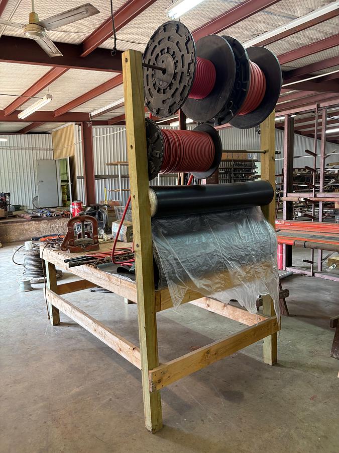 Used 8’ x 4’ x 8’ wooden shop table W/ bench vise, pipe vise, built in spool rack, 9/16” to 1-1/8” rubber hose, extension cords, etc