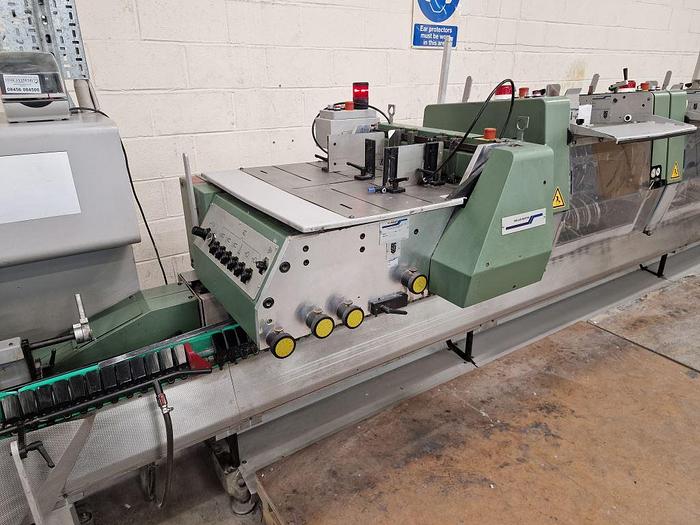 Used MULLER MARTINI BRAVO 6 Station Chain, 6 x 370 Feeders, 1 x Cover Feeder, Bravo Stitching Unit, Three Knife Trimmer, Pratico Stacker Delivery