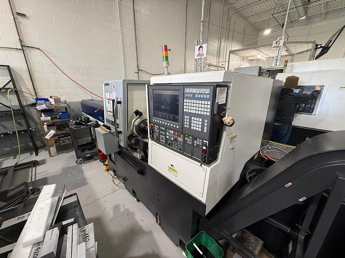 Used 2018 Okuma GENOS L300-M-e Lathe w/ Bar Feeder and Conveyor