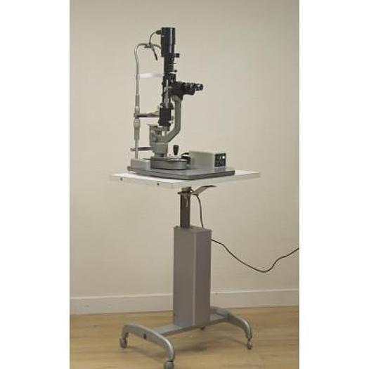 Used MAGNON SLIT LAMP WITH THREE-DIMENSIONAL MOVEMENTS AND LEVELLING TONOMETER, ON HEIGHT-ADJUSTABLE TABLE WITH CASTORS