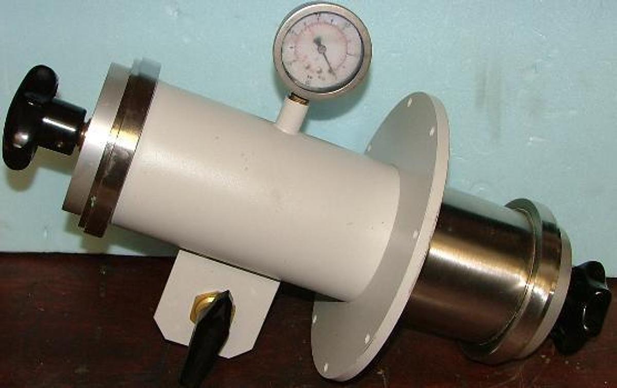 Used VACUUM CANISTER WITH SCREW ON TOP AND BOTTOM WITH PRESSURE RELEASE BALL VALVE AND 0 TO -15 PSI GAUGE.