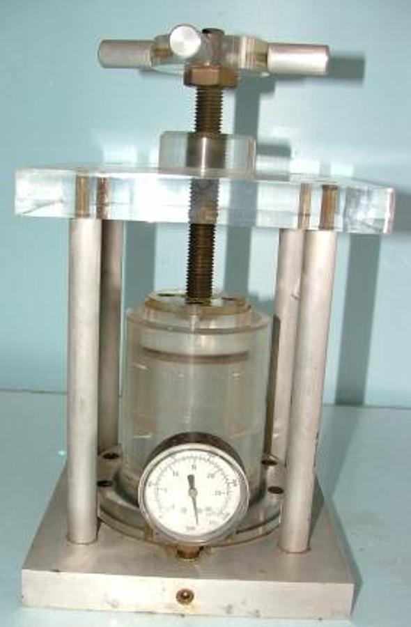 Used QTY. 1. ACRYLIC PRESS WITH 0-30 PSI GLASS PRESSURE GAUGE. AND 2 BRASS MULTI HOLE DIES.